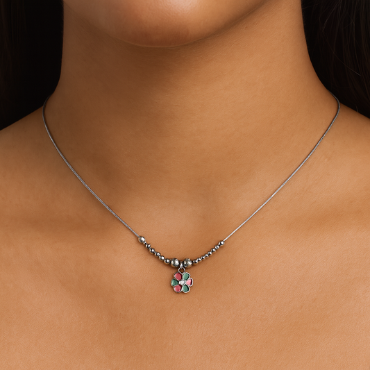 Necklace with a flower-shaped pendant on a person's neck against a dark background