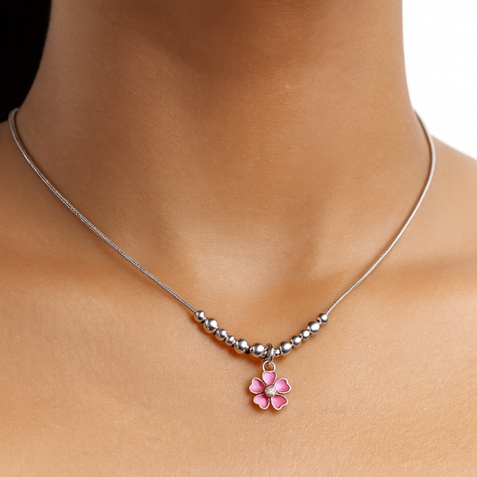 Necklace with a pink flower pendant on a person's neck