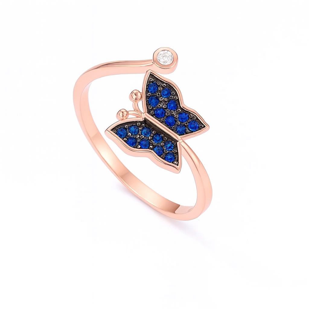 Rose gold ring with blue gemstone butterfly design on a white background