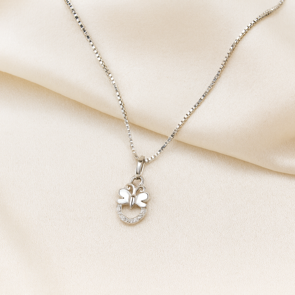 Silver necklace with a heart-shaped pendant on a beige fabric background