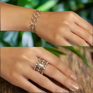Silver bracelet and ring on a hand against a white background